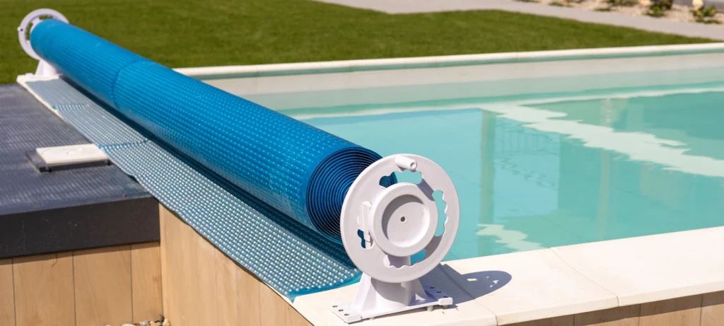 Swimming pool cover for protection against dirt, leaves, heating and cooling water, copy space. Blue tarpaulin pool cover. Summer day