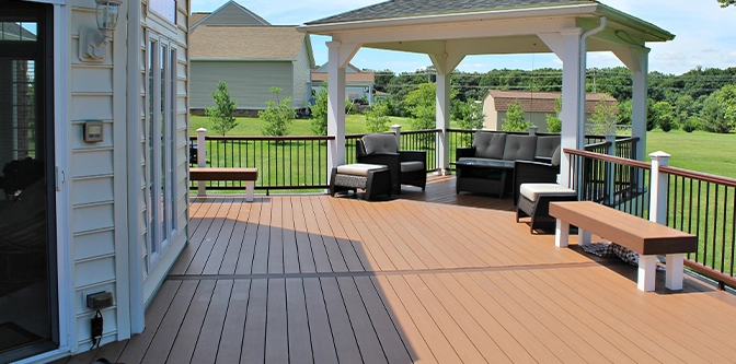 above ground deck with railing toward backyard lawn, seating setup under gazebo