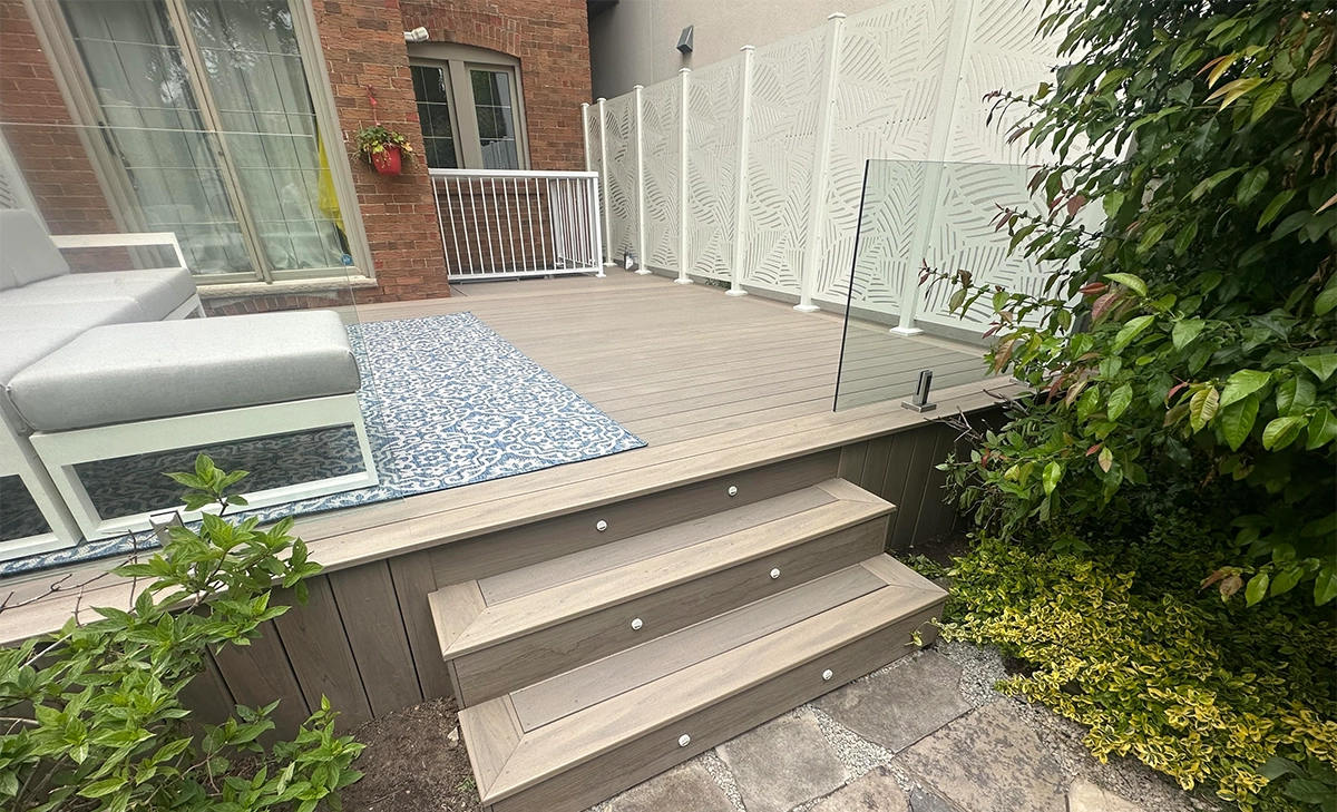 built in lighting feature in steps, deck with glass railing, privacy screen, seating setup, deck restoration