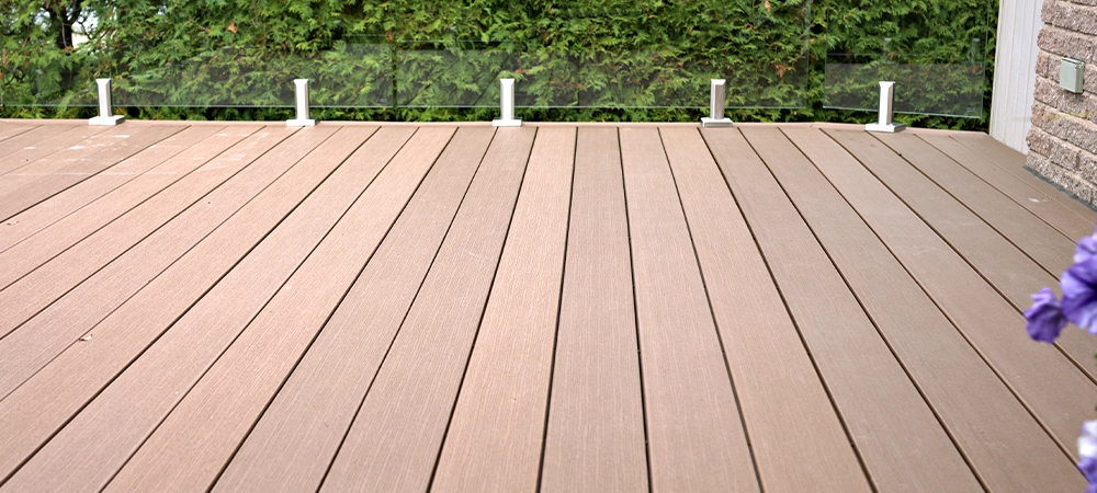 Composite deck with glass panel railing as a durable solution.