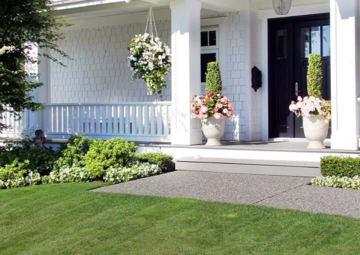 Beautiful new luxury home exterior in summer. Custom house with a porch and professional landscaping in Canada.