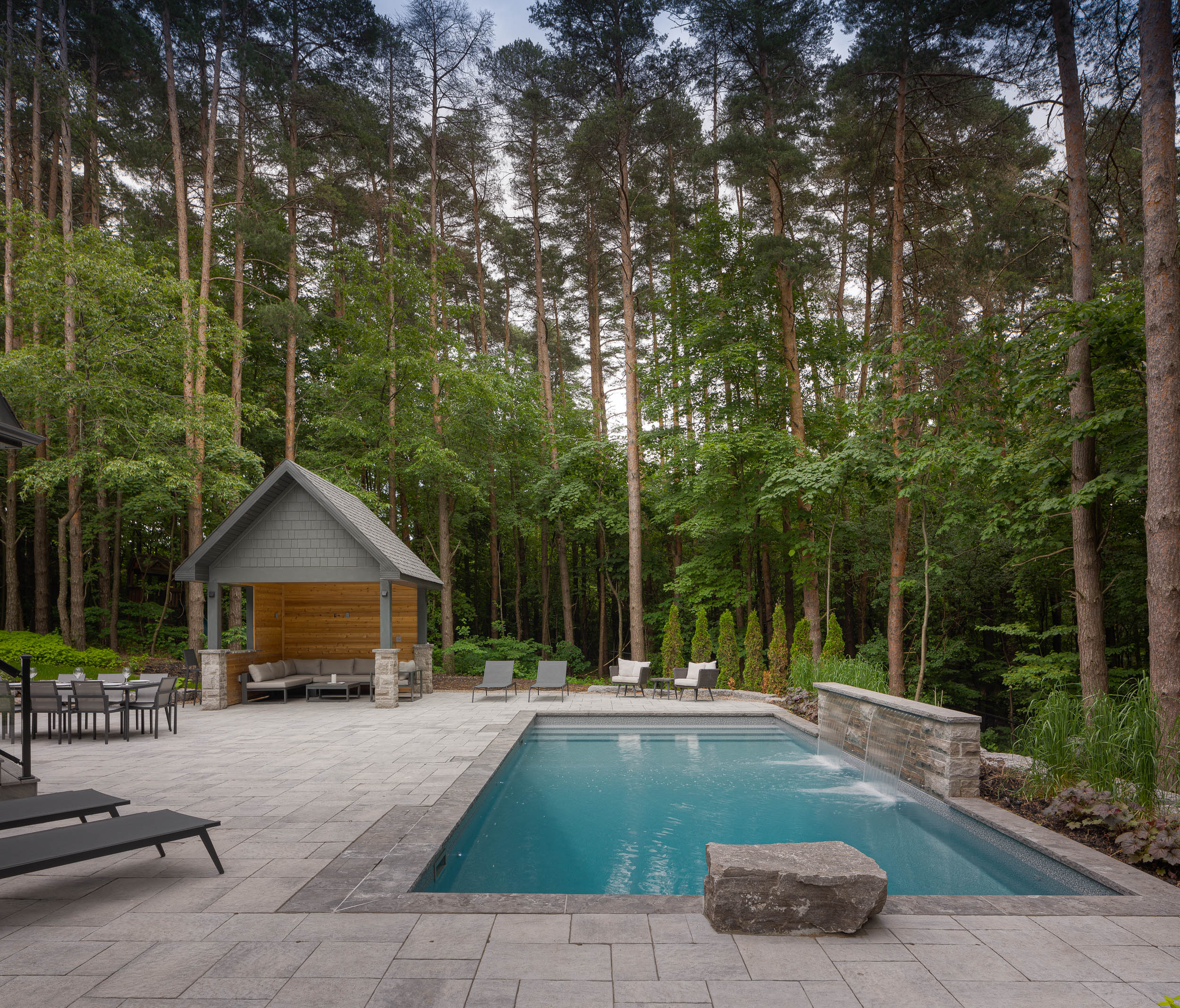 backyard in a forest with a pool