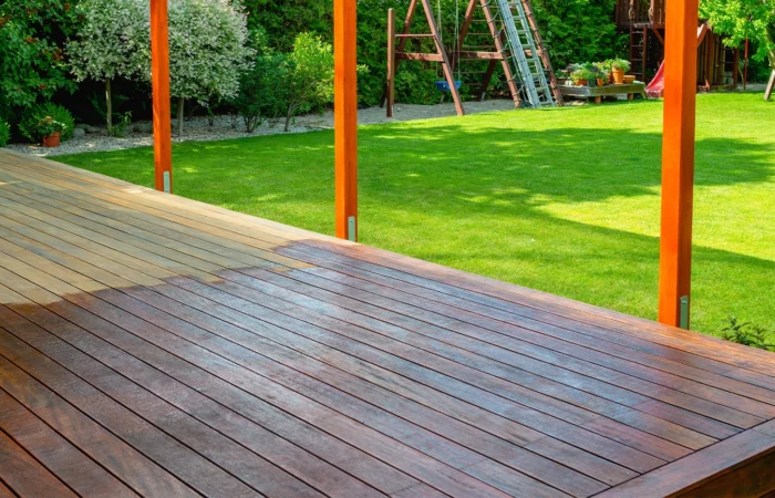 Close-up of a wooden deck - on the covered terrace - showing the process of restoration with a half-stained surface contrasting weathered and treated wood during a home improvement project
