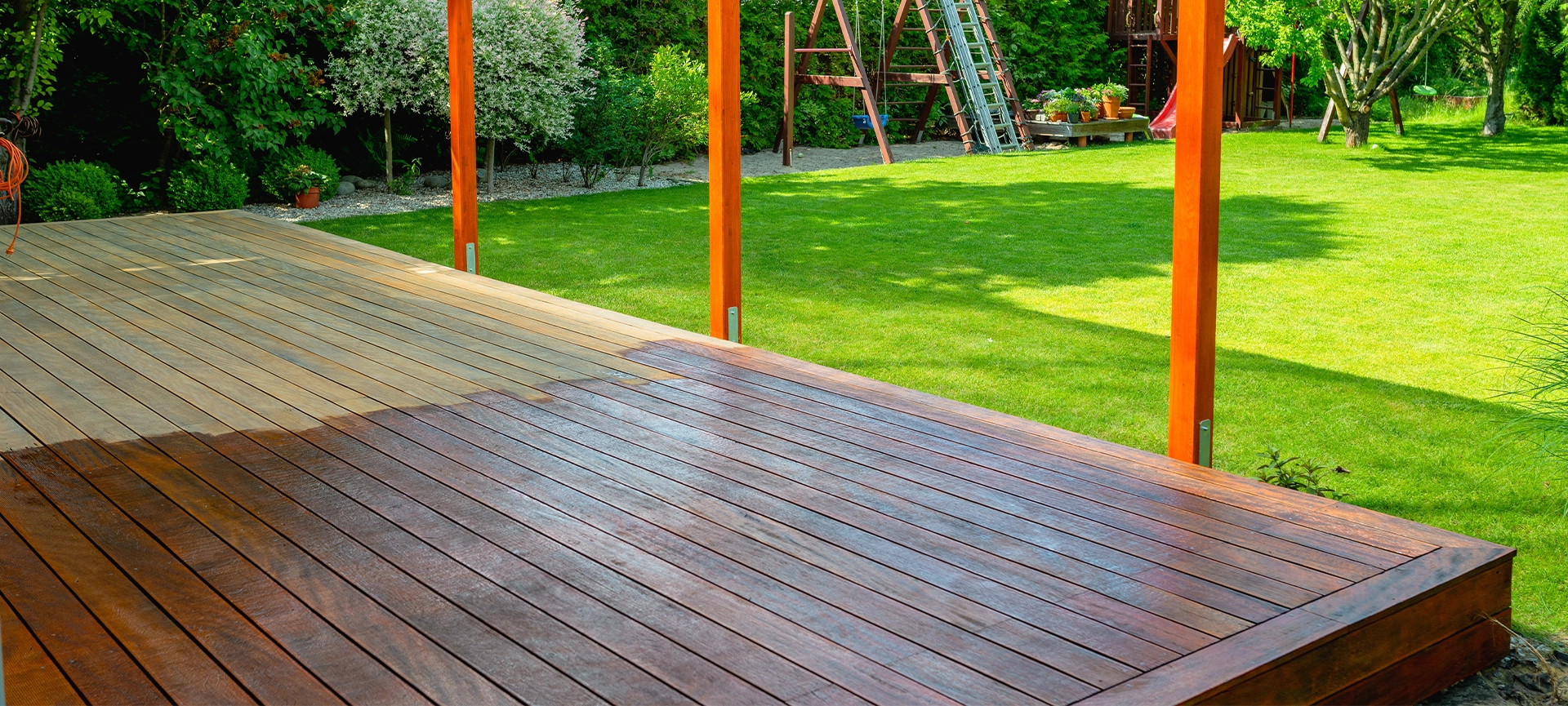 Close-up of a wooden deck - on the covered terrace - showing the process of restoration with a half-stained surface contrasting weathered and treated wood during a home improvement project