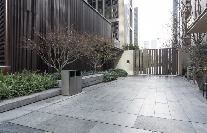 Modern urban commercial district courtyard with paved walkway and landscaped greenery