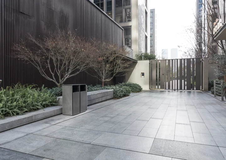 Modern urban commercial district courtyard with paved walkway and landscaped greenery