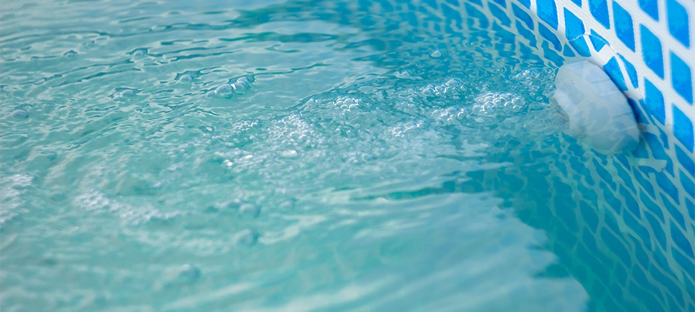 A clean jet of water that passes through the filter is injected back into the frame pool, forming bubbles on the surface of the water