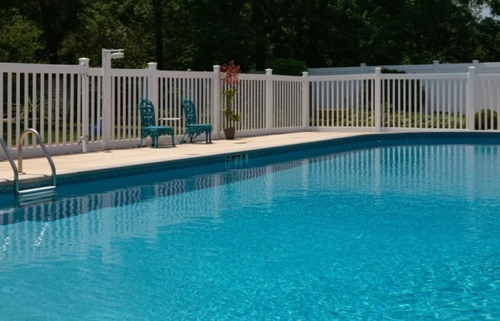 Outdoor photo of white vinyl fence around pool