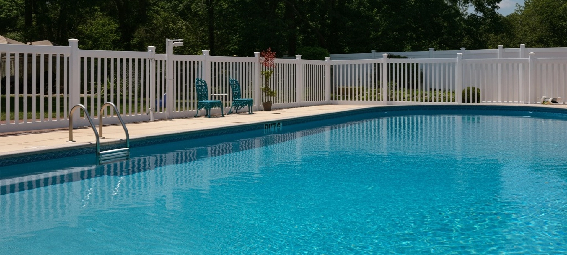 Outdoor photo of white vinyl fence around pool