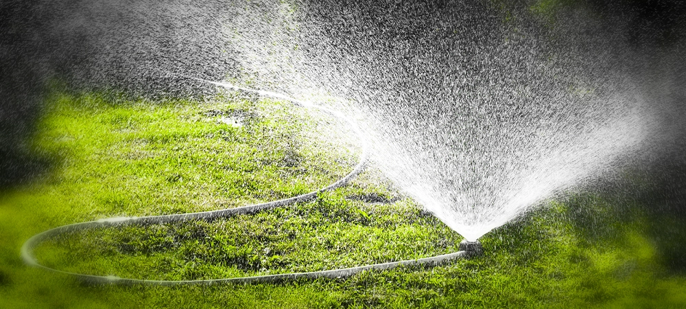 Watering the lawn of a private house with the help of irrigation sprinkler.