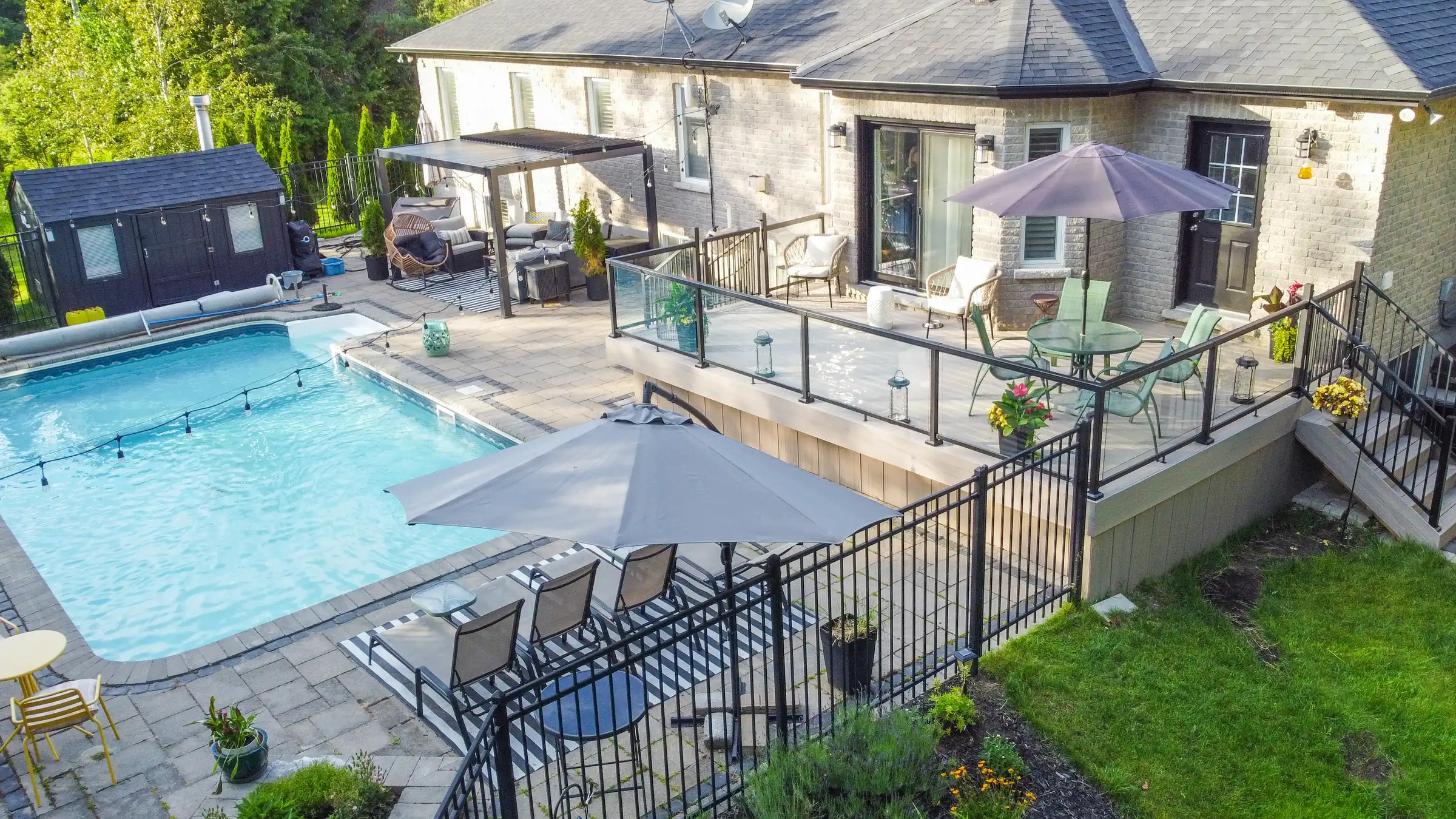 aerial-backyard-pool-deck-pergola-view large trex deck and beautiful pool interlocking