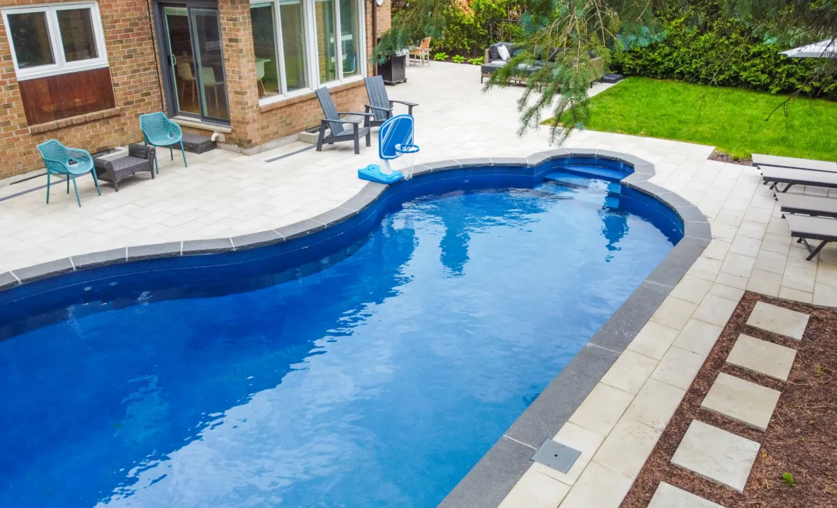 Aerial view of a backyard pool with lounge patio