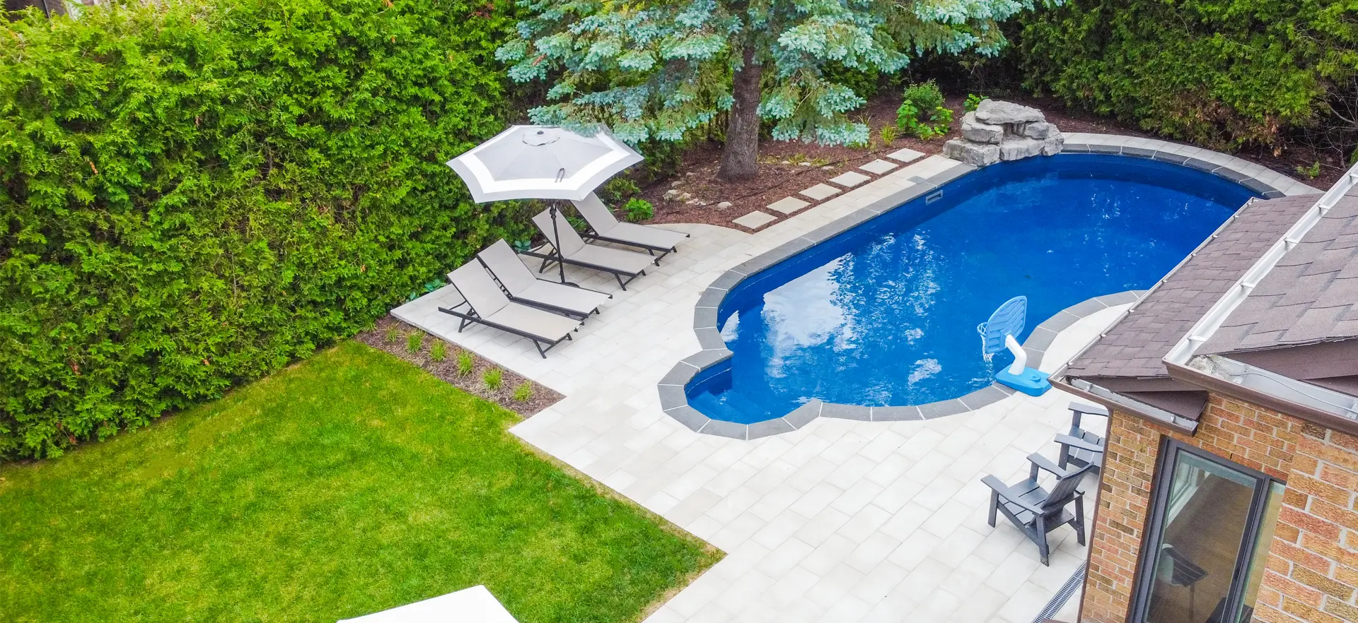 big backyard with pool, interlock, and grass area