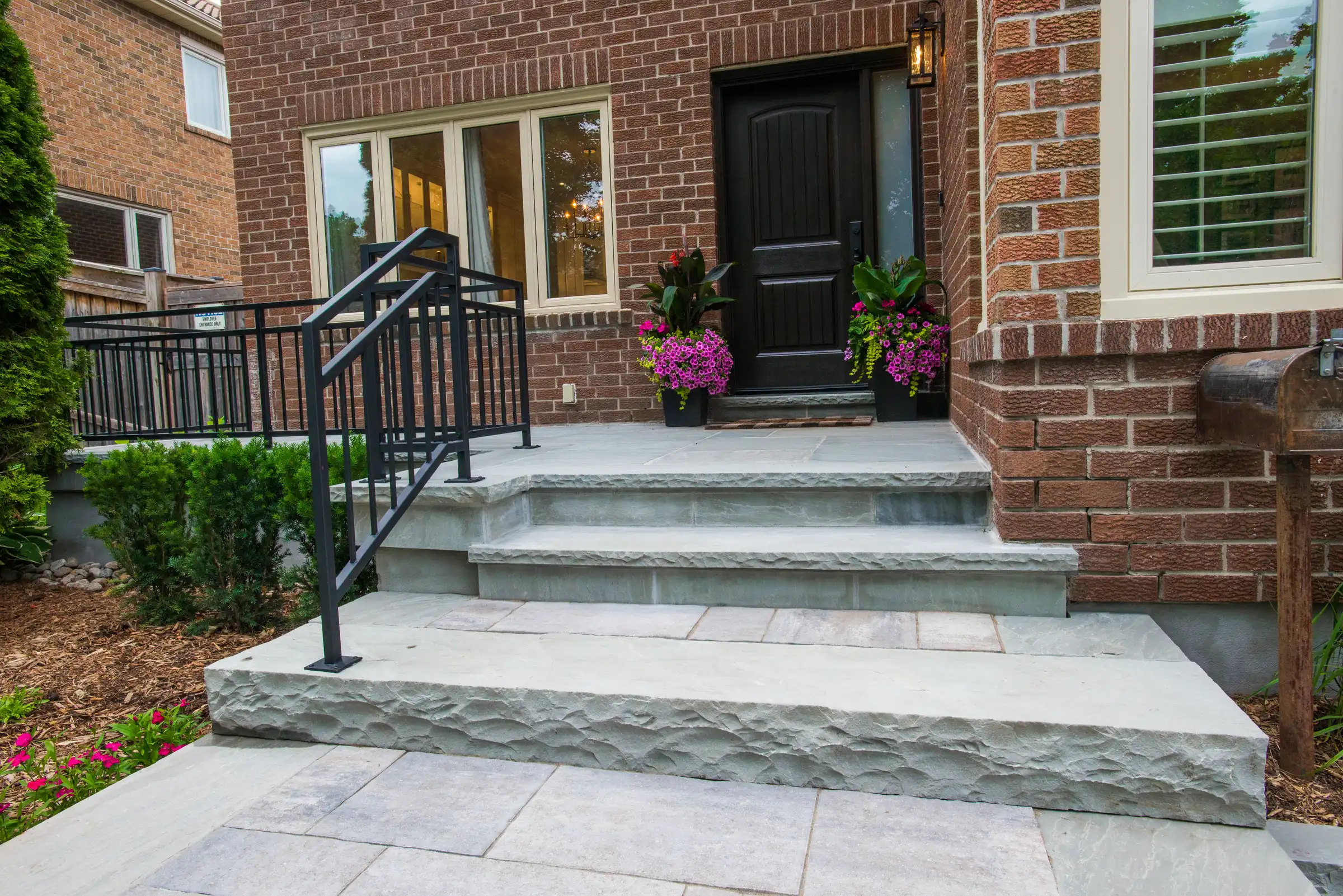 black front door with interlocked stairs