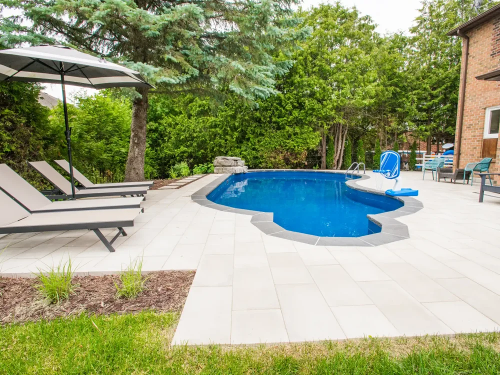 Paver walkway with stepping stones beside a pool and waterfall