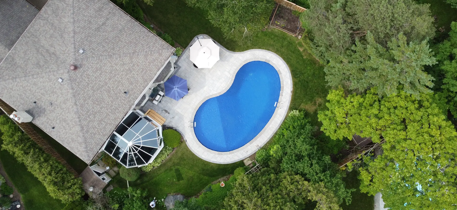 large backyard with a pool and interlocking around