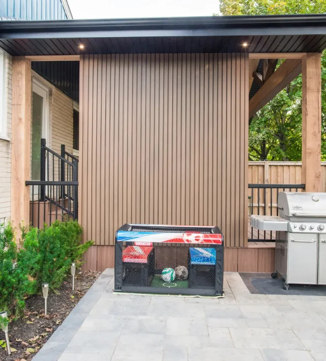 Privacy screen wall with grill beside a pergola
