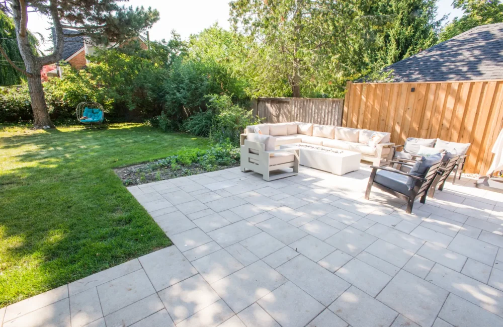 Backyard interlocking patio with sectional and swing chair