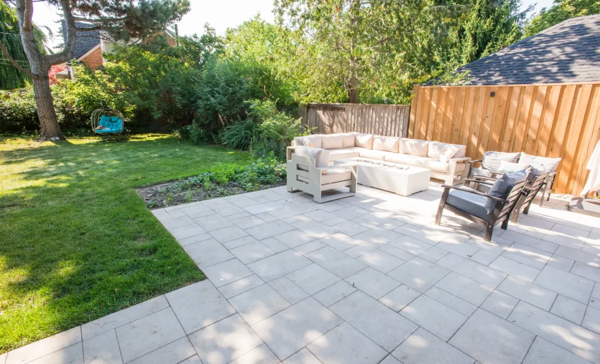 Backyard interlocking patio with sectional and swing chair