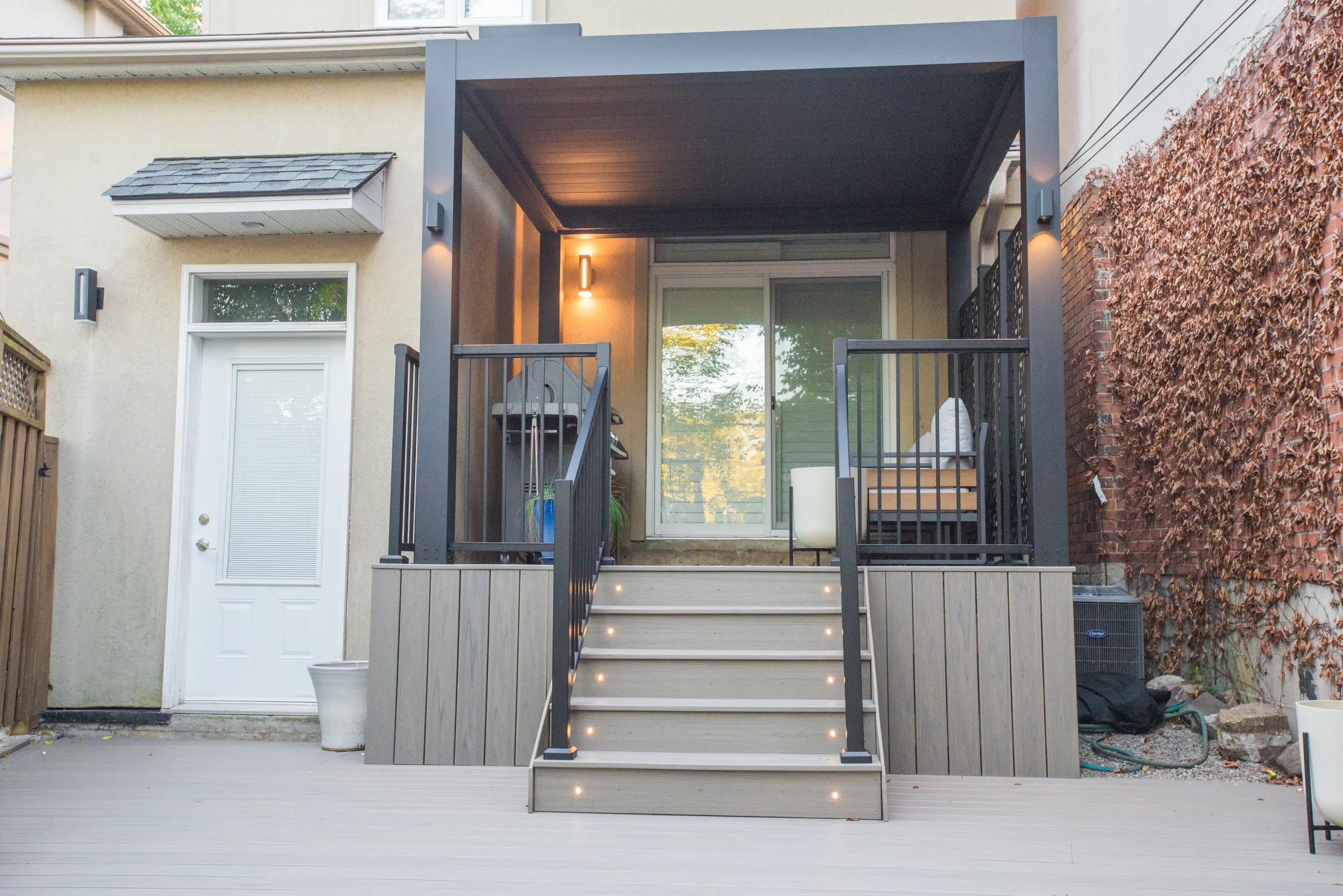 Front view of the electric pergola over lit Trex steps