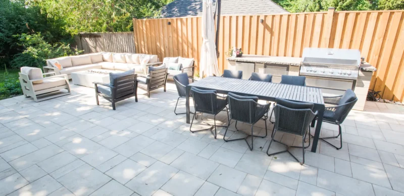 Interlocking patio with dining table, sectional and outdoor kitchen
