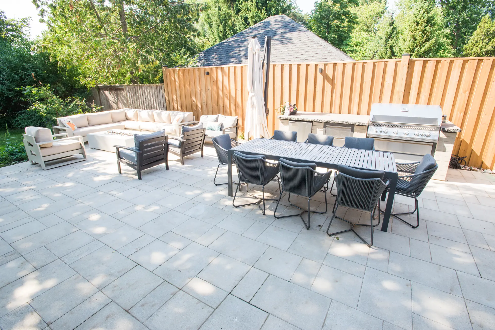 Interlocking patio with dining table, sectional and outdoor kitchen