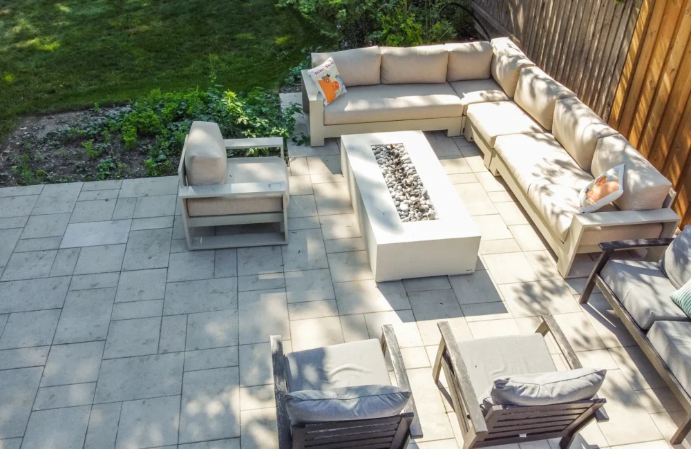 Patio sectional sofa around a fire pit table on interlocking stone