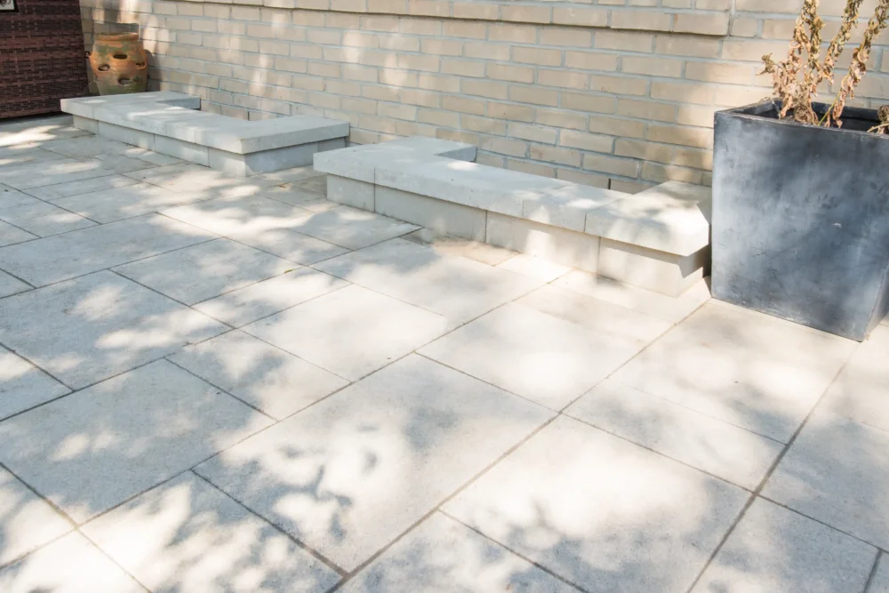 Natural stone bench and corner planter on interlocking patio