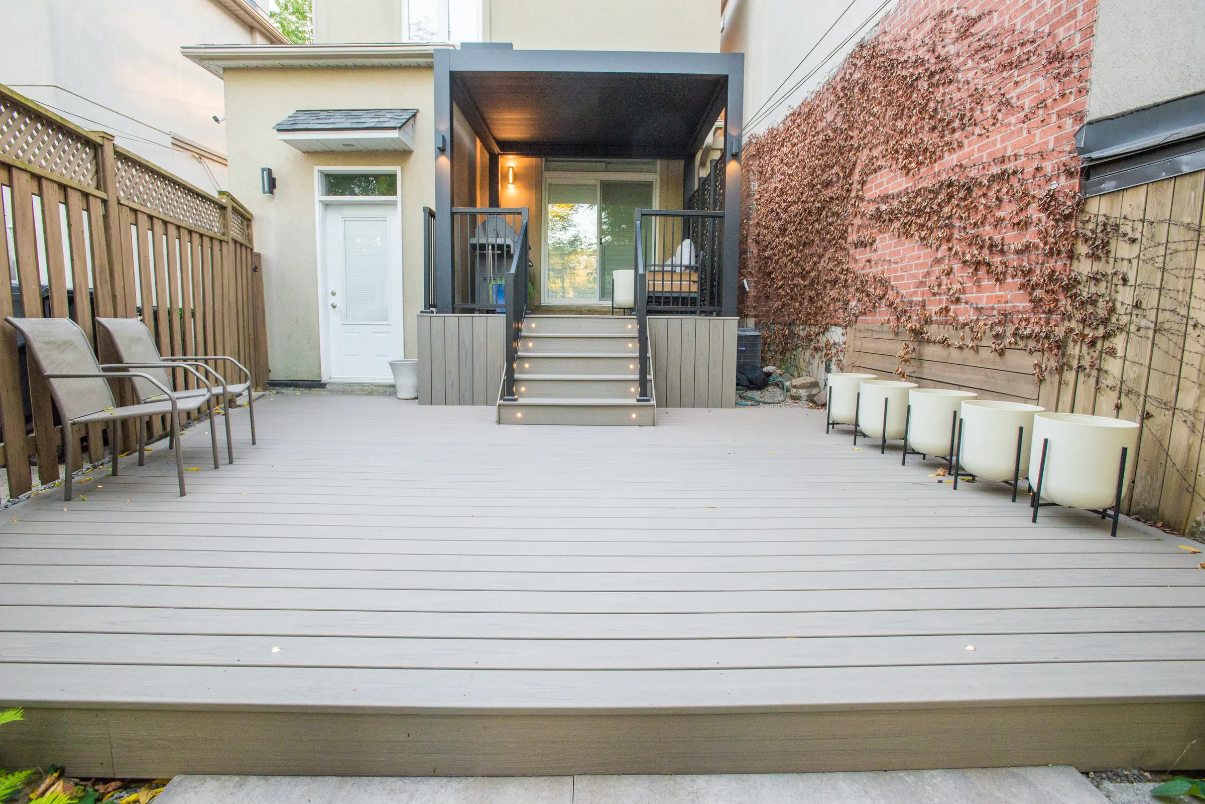 Wide view of the Trex deck with planters and the electric pergola